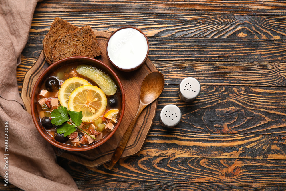 Φωτογραφία Bowl of tasty Hodgepodge soup with sour cream and bread on wooden background