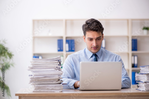 Young male employee and too much work in the office