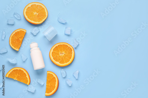 Deodorant with orange slices and ice on blue background