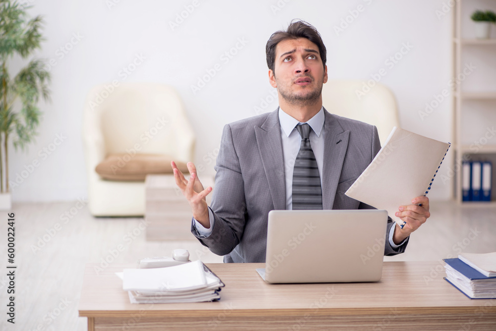 Young male employee working in the office Young male employee working in the office