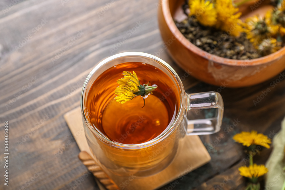 Bowl and glass cup of healthy dandelion tea on wooden background Bowl and glass cup of healthy dandelion tea on wooden background