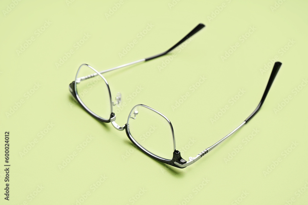 Stylish modern eyeglasses on pale green background Stylish modern eyeglasses on pale green background