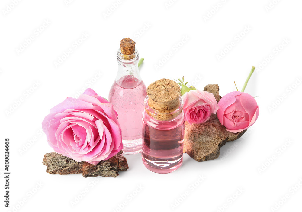 Bottles of cosmetic oil with rose extract and flowers on white background Bottles of cosmetic oil with rose extract and flowers on white background