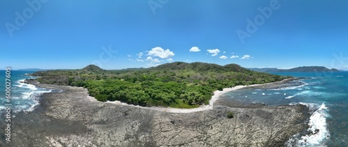 A pristine tropical beach in Costa Rica, with palm trees swaying in the breeze, crystal clear water, soft white sand, and vibrant wildlife in the surrounding rainforest.	 photo