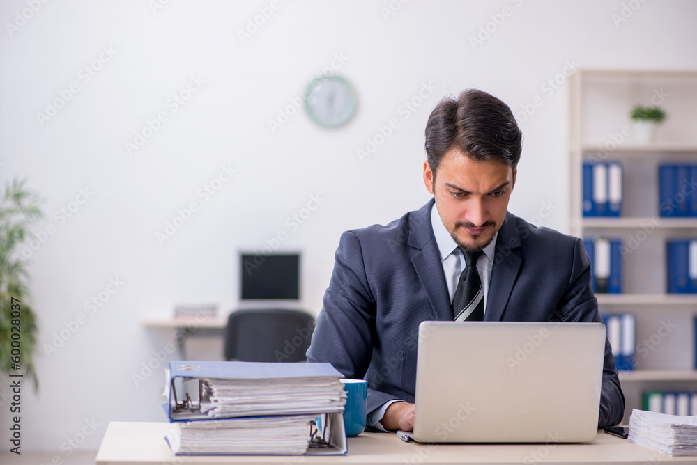 Young male employee sitting at workplace