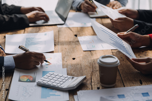 Financial analysts analyze business financial reports on a digital tablet planning investment project during a discussion at a meeting of corporate showing the results of their successful teamwork.