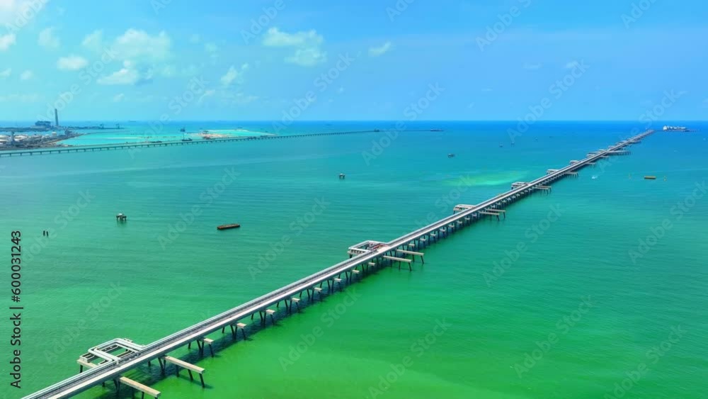 LNG terminal connected to a network of pipelines that transport LNG to and from tankers. The pipelines can be visible as long, cylindrical structures that extend from the terminal out into the sea.
LNG terminal connected to a network of pipelines that transport LNG to and from tankers. The pipelines can be visible as long, cylindrical structures that extend from the terminal out into the sea.