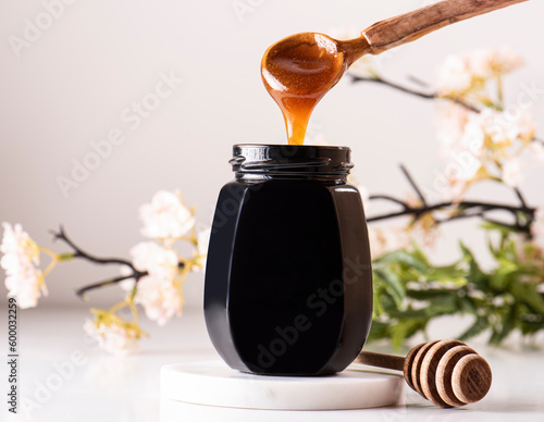 Manuka honey pouring into honey jar photo