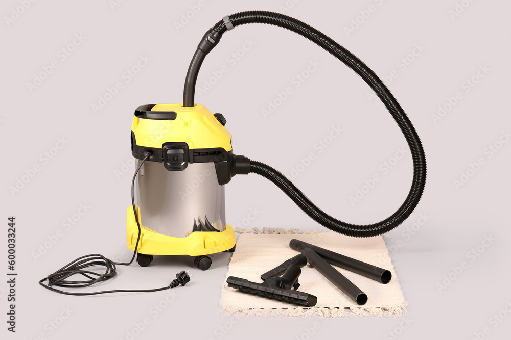 Vacuum cleaner with rug on grey background Vacuum cleaner with rug on grey background