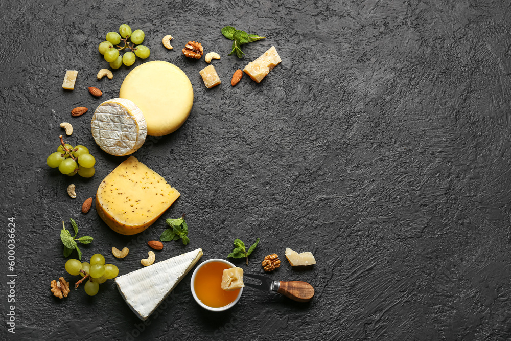 Frame made of tasty cheese, nuts, grapes and honey on black background Frame made of tasty cheese, nuts, grapes and honey on black background