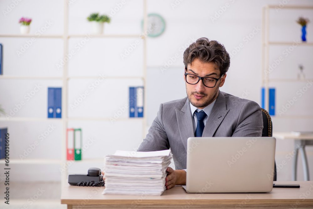 Young male employee sitting at workplace Young male employee sitting at workplace