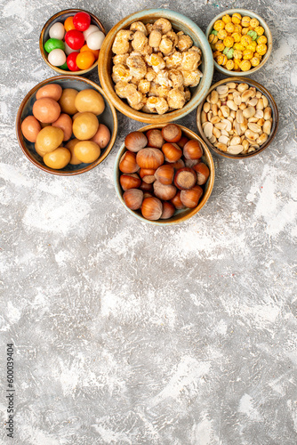 top view hazelnuts and peanuts with candies on white background nut hazelnut walnut snack candy