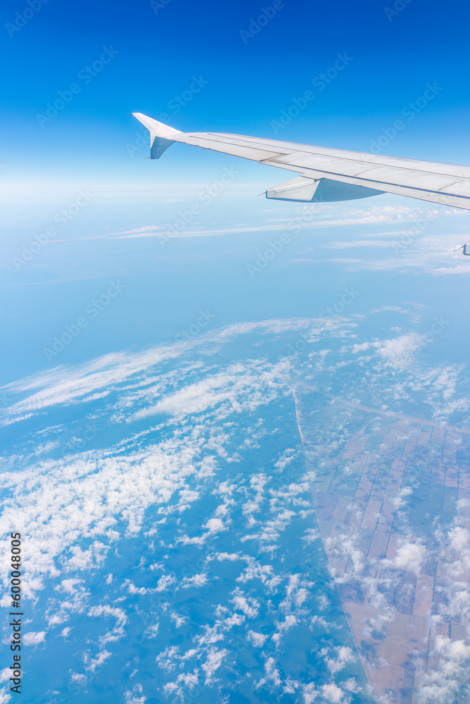 View from the airplane window at a beautiful cloudy sky and the airplane wing