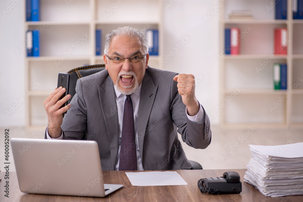 Old male employee working in the office Old male employee working in the office