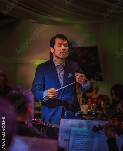 Closeup view of male conductor conducting classical concert in informal setting