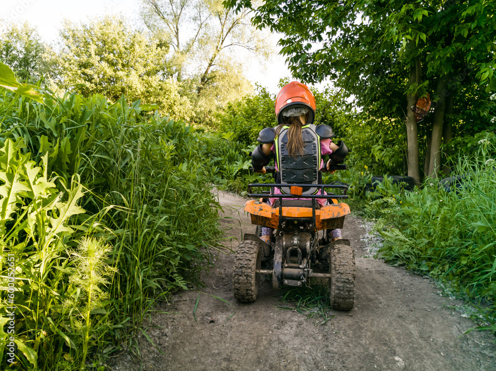 Obraz premium A child rides a quad bike through the mud. ATV rider rides