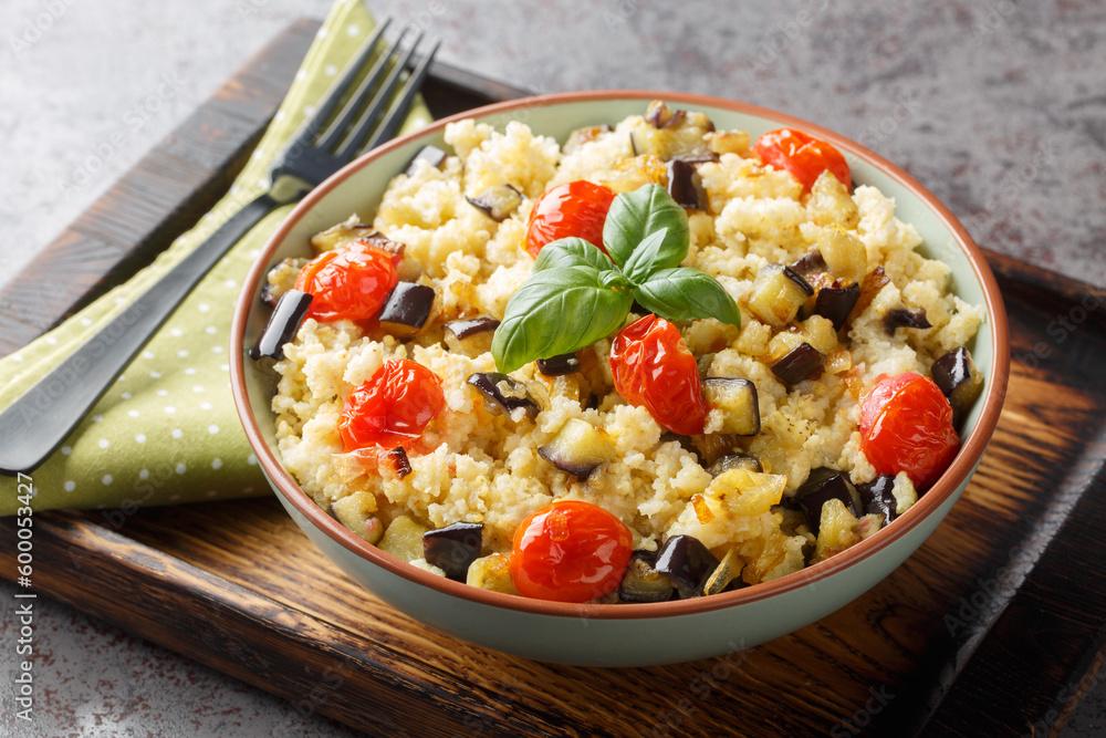 Tasty millet with tomato, eggplant, onions close-up in a bowl on the table. Horizontal Tasty millet with tomato, eggplant, onions close-up in a bowl on the table. Horizontal