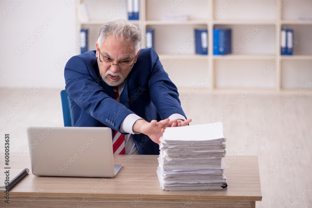 Old male employee unhappy with excessive work in the office