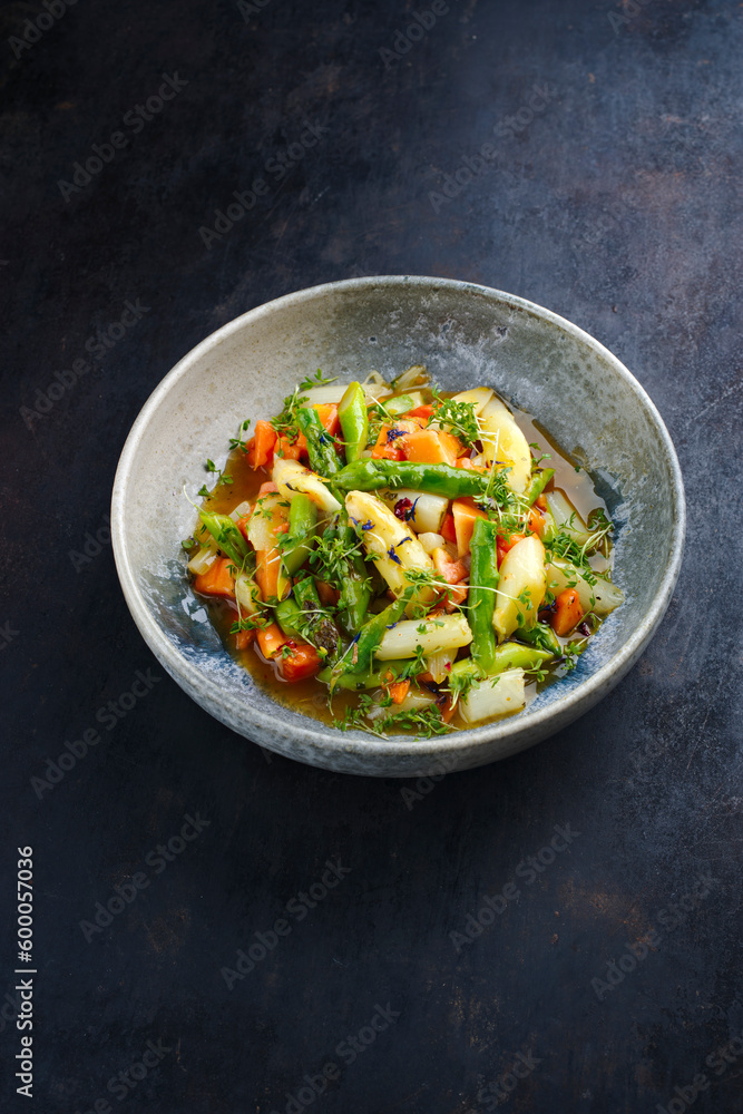 Green and white asparagus glazed with papaya in sweet vinaigrette served as close-up in a design plate with text space Green and white asparagus glazed with papaya in sweet vinaigrette served as close-up in a design plate with text space