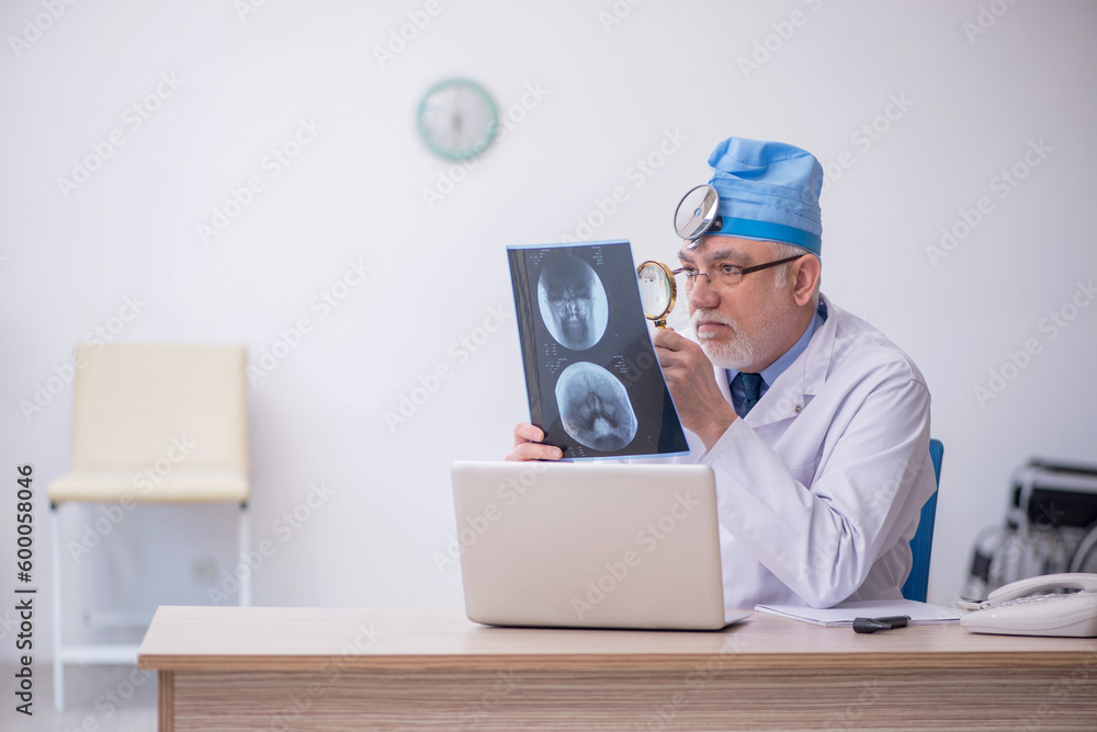 Old male docror otolaryngologist working in the clinic Old male docror otolaryngologist working in the clinic