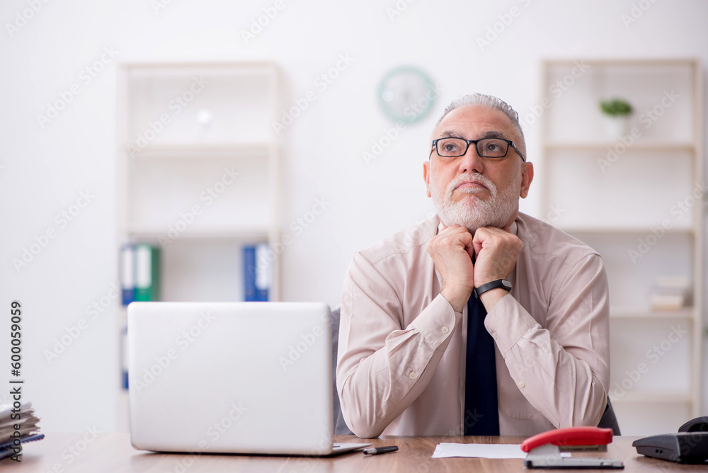 Old male employee working in the office Old male employee working in the office