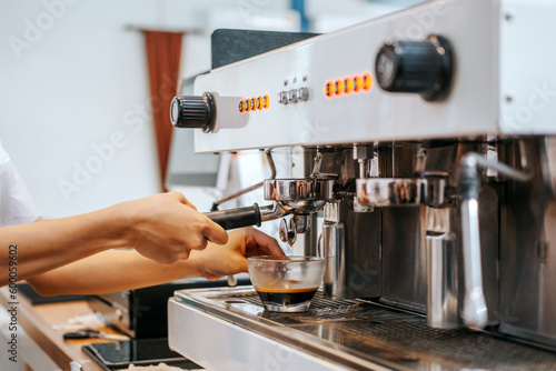 Barista hands coffee barista woman make hot cup espresso shot from coffee machine.