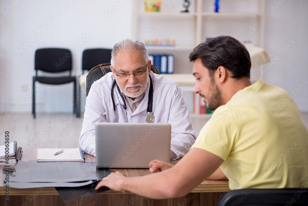 Young male patient visiting old male doctor Young male patient visiting old male doctor