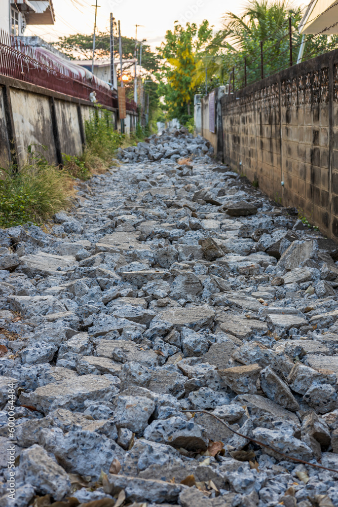 A background view of a smashed concrete road lined with rubble.