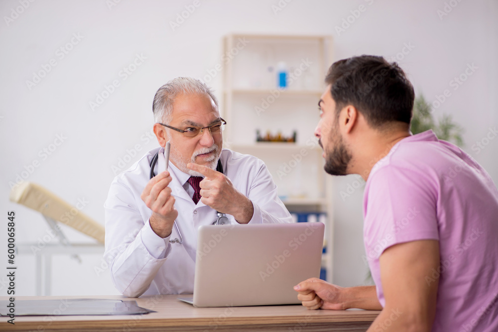 Young male patient visiting old male doctor Young male patient visiting old male doctor