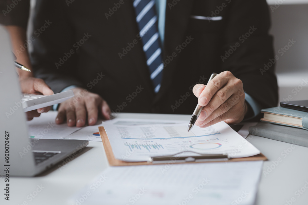 Businessman is reviewing monthly sales documents for analysis and marketing plans for more sales growth, they are the founders of young companies co-founding startups. Sales management concept. Businessman is reviewing monthly sales documents for analysis and marketing plans for more sales growth, they are the founders of young companies co-founding startups. Sales management concept.