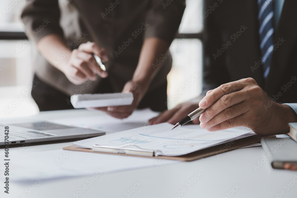 Fototapeta premium Businessman is reviewing monthly sales documents for analysis and marketing plans for more sales growth, they are the founders of young companies co-founding startups. Sales management concept.
