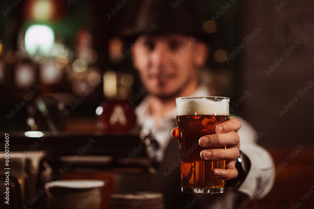 bartender serves in hand a glass of light draft beer lager with foam at bar counter in pub bartender serves in hand a glass of light draft beer lager with foam at bar counter in pub