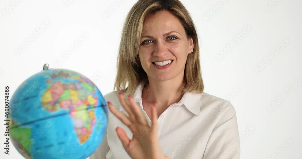 Smiling happy beautiful woman spins globe. World tourism and travel Smiling happy beautiful woman spins globe. World tourism and travel
