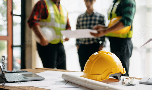 Engineer teams meeting working together wear worker helmets hardhat on construction site in modern city.Asian industry professional team.