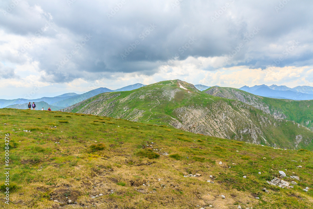 View of the tops of the Czerwone Wierchy massif: Krzesanica (left) and Ciemniak (back right) from the top of Małołączniak in the Western Tatras (Poland) on a cloudy summer day.