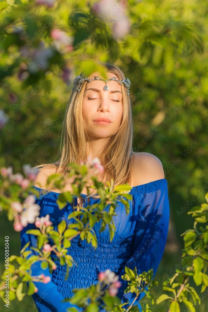 Femininity concept, tender modern European lady in blue dress at evening garden Femininity concept, tender modern European lady in blue dress at evening garden