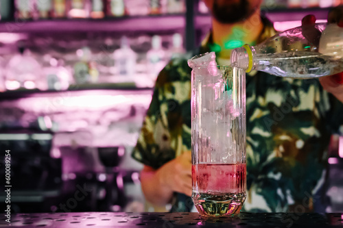 man bartender making cold gin tonic cocktail in bar