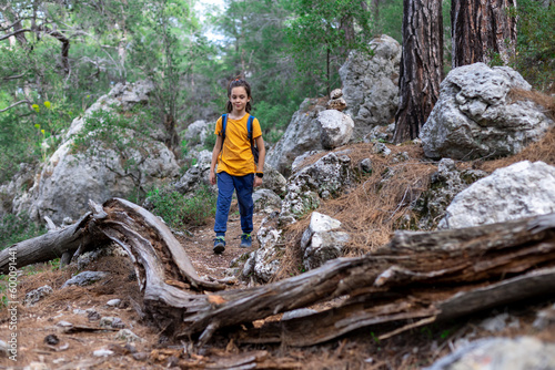 Adventure and travel. a little boy with a backpack is walking along a forest path. hiking with children.