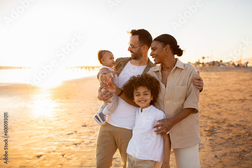Beachside bonding. Happy multiracial family walking and enjoying time together on beach during holidays © Prostock-studio
