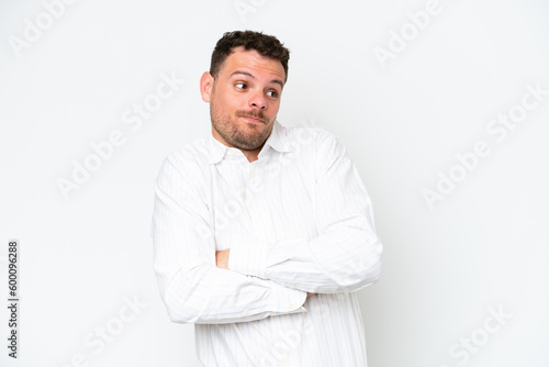 Young caucasian handsome man isolated on white background making doubts gesture while lifting the shoulders © luismolinero