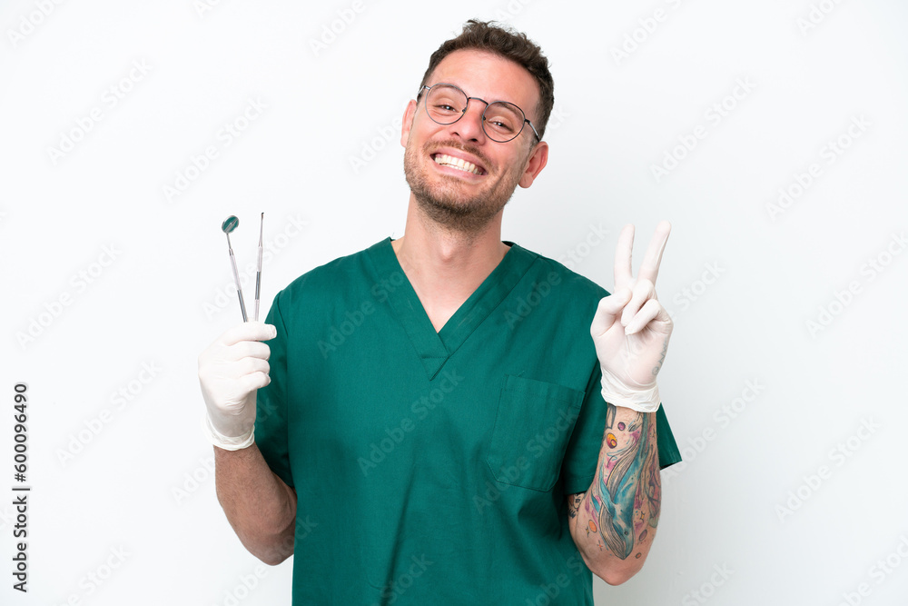 Young caucasian dentist man isolated on white background smiling and showing victory sign