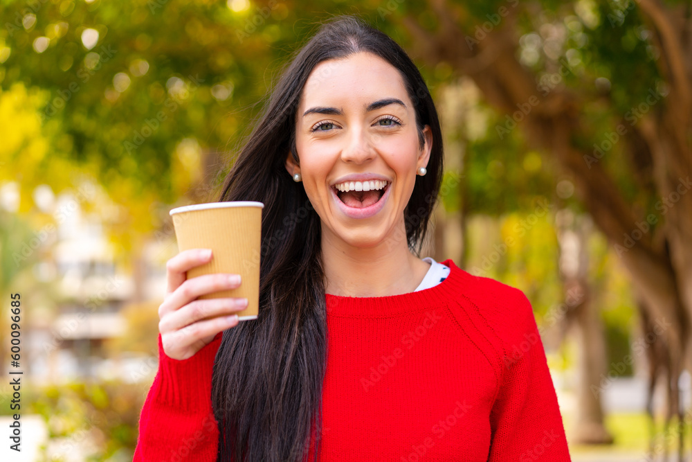 Young woman holding a take away coffee at outdoors with surprise and shocked facial expression Young woman holding a take away coffee at outdoors with surprise and shocked facial expression