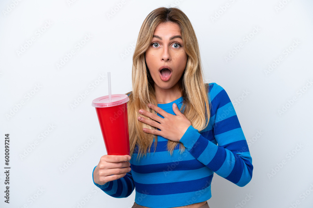 Young Uruguayan woman drinking soda isolated on white background surprised and shocked while looking right Young Uruguayan woman drinking soda isolated on white background surprised and shocked while looking right
