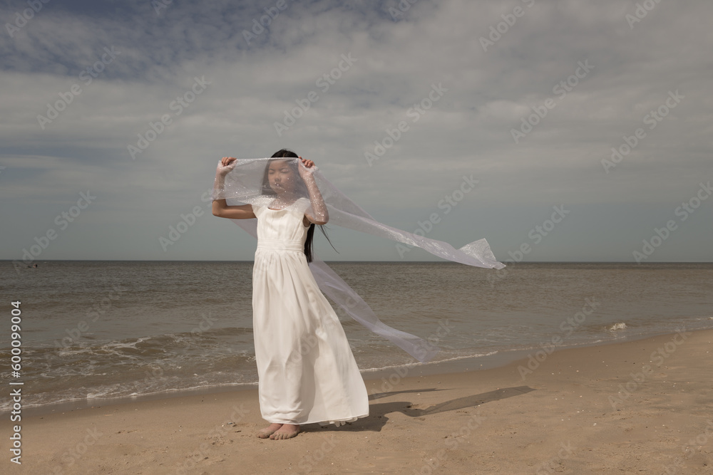girl in white dress dancing with veil on beach girl in white dress dancing with veil on beach