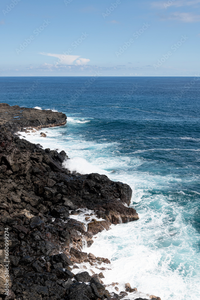 A Stunning Shot of the Turquoise Waters of Réunion Island, Framed by Majestic Rocky Cliffs and a Clear Blue Sky, with copy space, La Réunion, France A Stunning Shot of the Turquoise Waters of Réunion Island, Framed by Majestic Rocky Cliffs and a Clear Blue Sky, with copy space, La Réunion, France