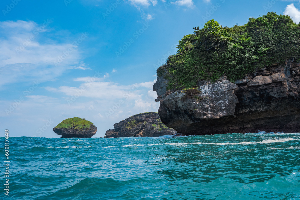 Rock formation on the ocean near the Tanjung Kasap or Cape Kasap, Pacitan, Indonesia. Taken from a moving boat. Rock formation on the ocean near the Tanjung Kasap or Cape Kasap, Pacitan, Indonesia. Taken from a moving boat.