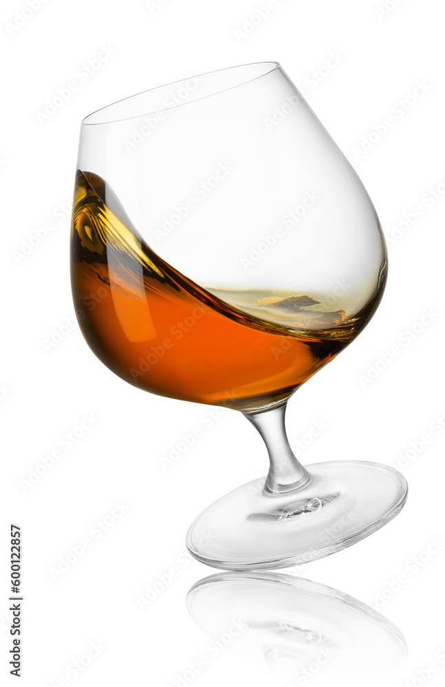 falling glass of cognac with splash isolated on white falling glass of cognac with splash isolated on white