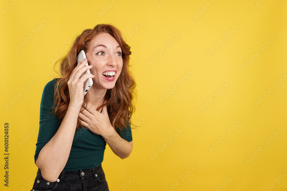 Redheaded woman receiving good news by mobile phone Redheaded woman receiving good news by mobile phone