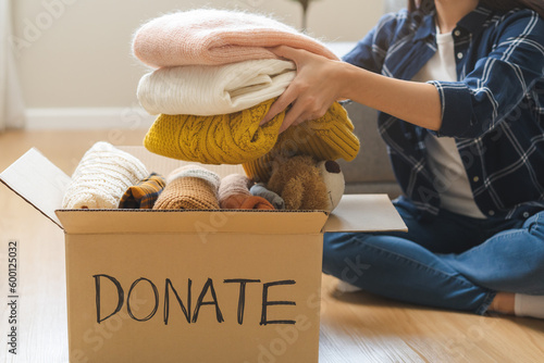 фотографія Recycling, Donation for poor, asian young woman, girl sitting pack object at home, putting on stuff into donate box with second hand clothes, charity helping and needy people