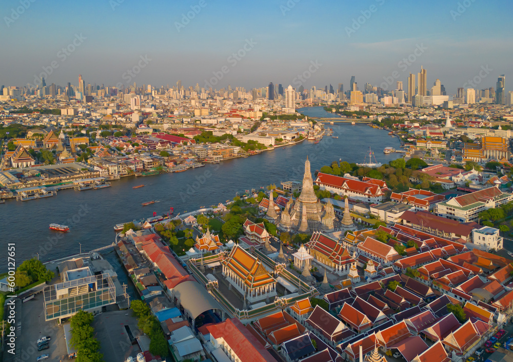 Aerial top view of Temple of Dawn or Wat Arun statue and Chao Phraya River, Bangkok, Thailand in Rattanakosin Island in architecture, Urban old town city, skyline at sunset.